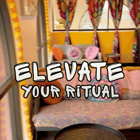 A wide shot of the Fly Loft interior showing a bright, maximalist lounge area with colorful stairs, eclectic decor, and a large circular mandala on the wall.