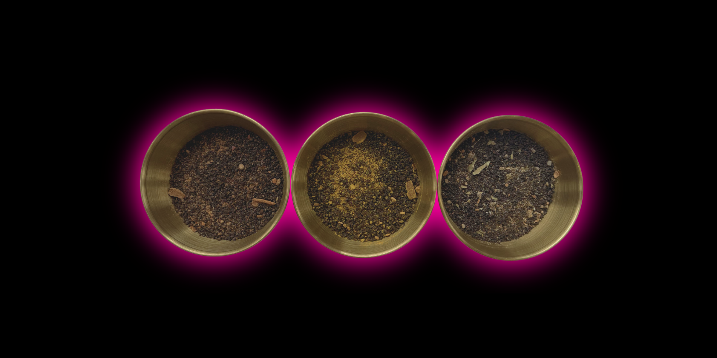 Three metallic bowls with dark contents on a black background