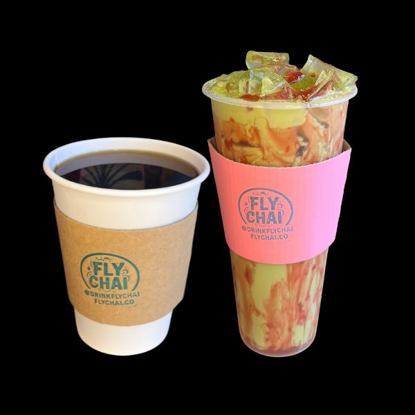 Two Fly Chai branded cups on a black background: a white paper coffee cup with a brown sleeve and a clear plastic iced drink cup with a pink sleeve showing orange and green marbled liquid inside.